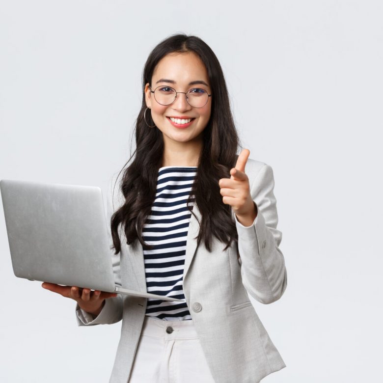 Business, finance and employment, female successful entrepreneurs concept. Smiling pleased businesswoman praise coworker who made good point, pointing finger camera satisfied, hold laptop.